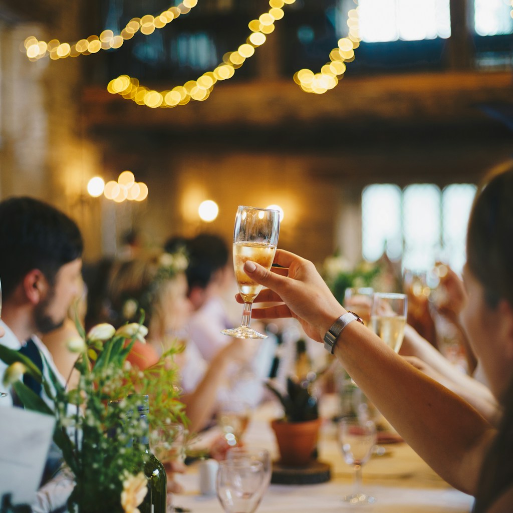 Friends raising drinks around a warmly lit table